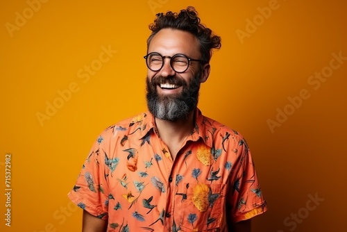 Handsome bearded hipster man with glasses over yellow background.