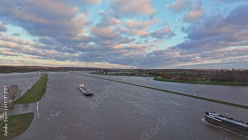 Following drone shot while Cargo ships pass each other on the river the rijn during high water levels. photo
