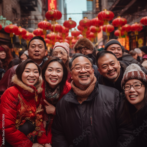 Group of joyful people, family and friends, smiling for a selfie during Chinese New Year celebrations with red lanterns in the background.  © Pixza