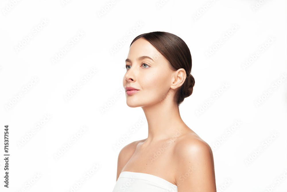 Full face profile beauty portrait of young beautiful woman with a clean glowing skin brown hair with a bun hairstyle wear white top with off shoulders isolated on white background Full face profile beauty portrait of young beautiful woman with a clean glowing skin brown hair with a bun hairstyle wear white top with off shoulders isolated on white background