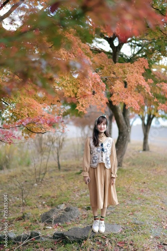 Casual dress elegance: Asian woman in Japan's fall beauty, a cheerful holiday portrait amid yellow and red foliage. A journey capturing the essence of nature, fashion, and casual elegance.