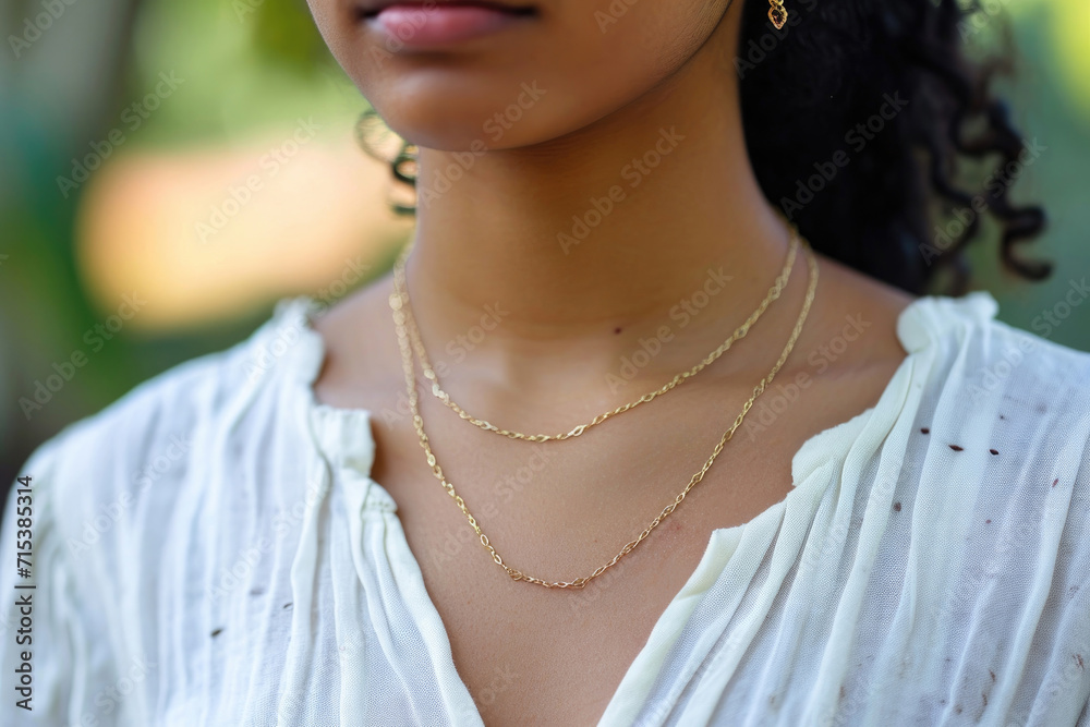 Radiant beauty emanates from a woman's neckline adorned with a radiant gold chain necklace