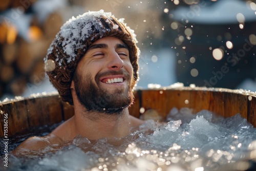 Male with bonnet taking therapeutical ice bath in wooden tub outdoor. 