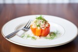 individual stuffed bell pepper on a small round dish, side view