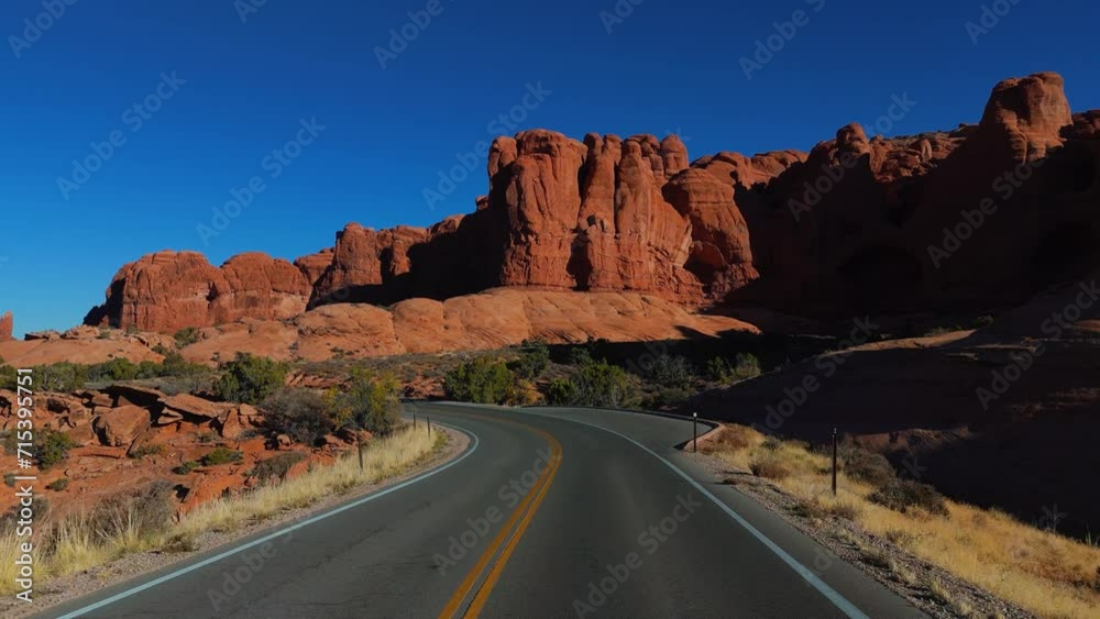 Arches National Park in Utah, USA. Cinematic road in the park with famous landmark, blue sky, red rock formations. Arches National Park in Utah, USA. Cinematic road in the park with famous landmark, blue sky, red rock formations.