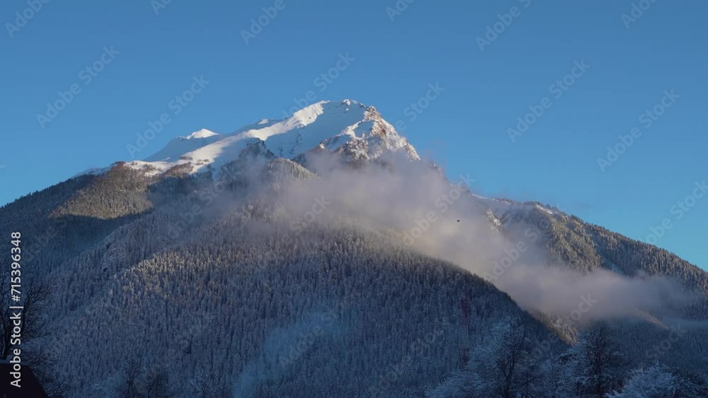Snowy mountain in fog on a blue sky Snowy mountain in fog on a blue sky
