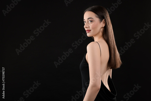 Beautiful young woman on black background, space for text