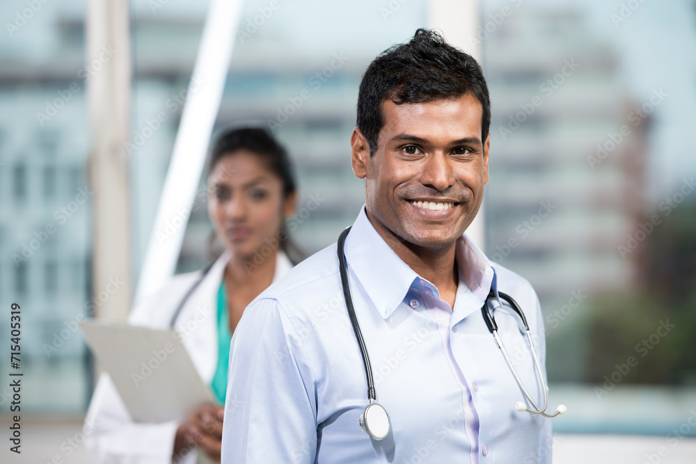 Male Indian doctor standing with his colleague Male Indian doctor standing with his colleague
