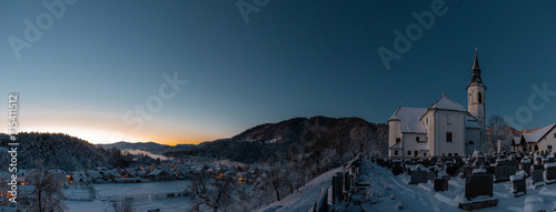 Beautiful village of Ljubno ob Savinji, home of female ski jump competition. Winter panorama from the church above the village in early morning. Sun rising over picturesque winterscape photo