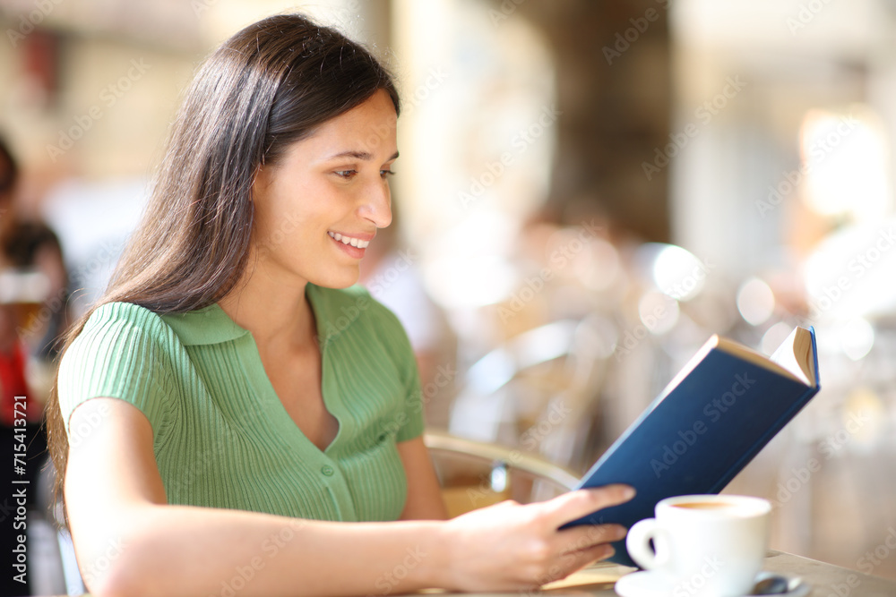 Happy woman reading a book in a terrace Happy woman reading a book in a terrace