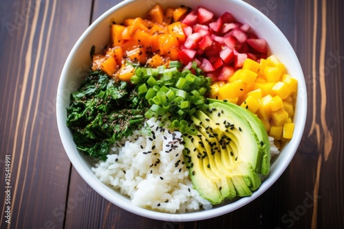  a bowl filled with rice, avocado, and other veggies on top of a wooden table.