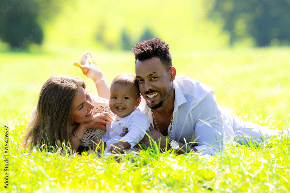 Mixed raced parents and Biracial baby outdoor portrait. Multiracial