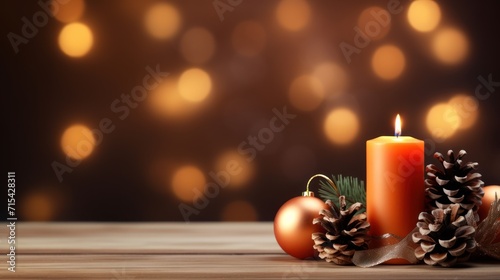  a candle that is sitting next to a christmas ornament with a pine cone on the top of it.