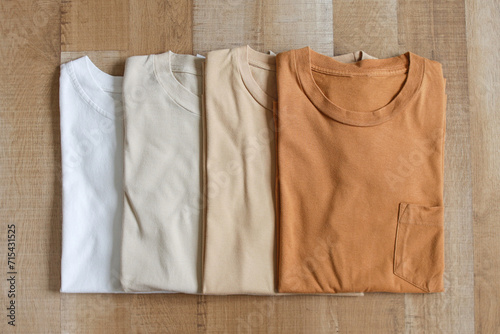 Top view of brown color variants t-shirts on wood plank background
