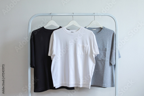 Set of mockup t-shirts in monochrome color on white hanger displaying on rack clothes