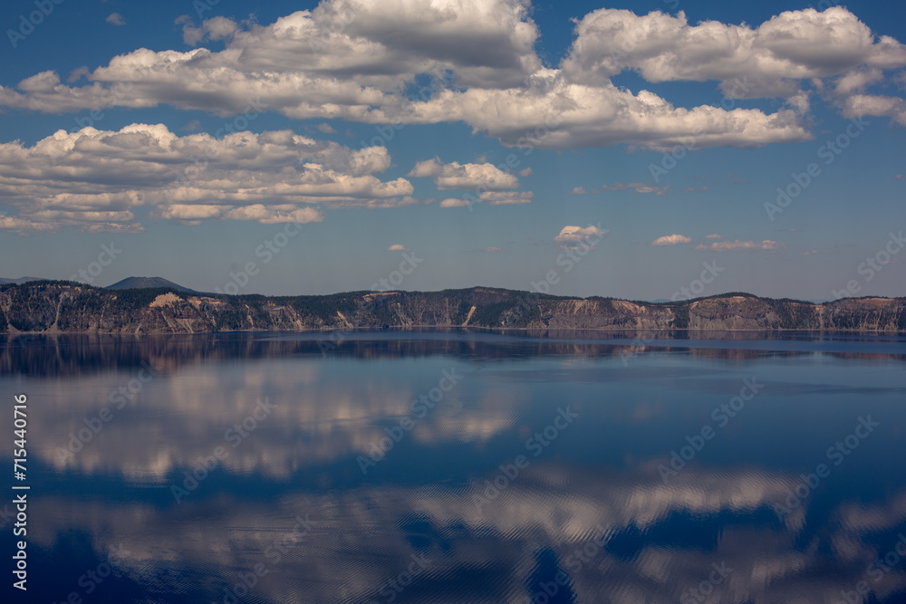 Calming lake with snow-capped mountain reflected in its tranquil waters, Crater Lake National Park, Oregon.