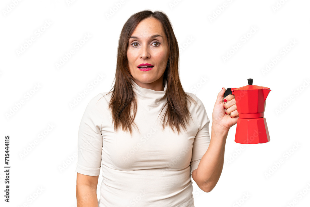 Middle-aged caucasian woman holding coffee pot over isolated background with surprise and shocked facial expression Middle-aged caucasian woman holding coffee pot over isolated background with surprise and shocked facial expression
