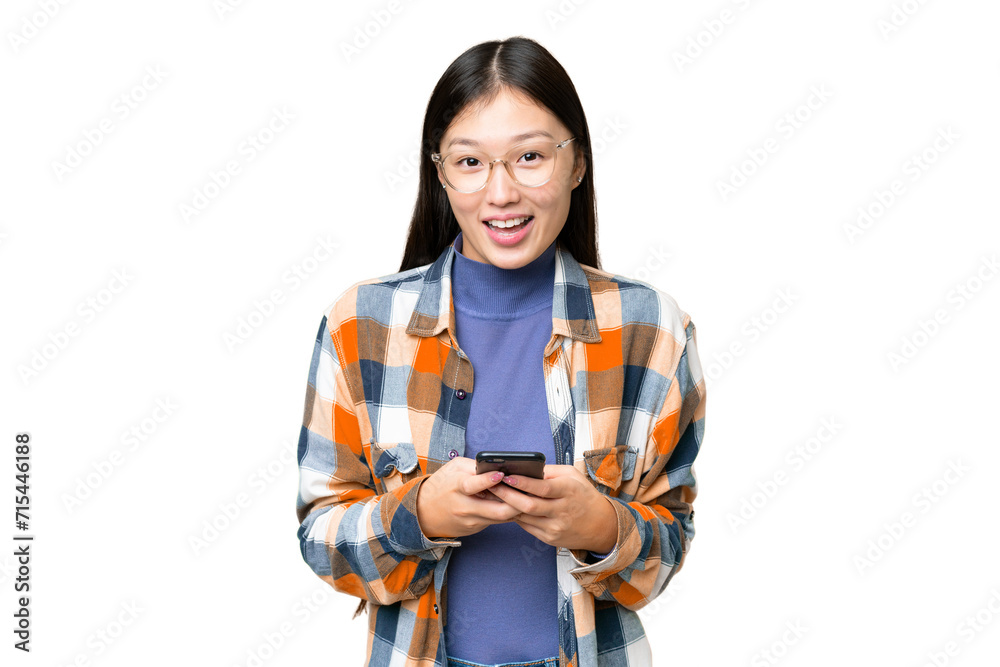 Young Asian woman over isolated chroma key background surprised and sending a message Young Asian woman over isolated chroma key background surprised and sending a message