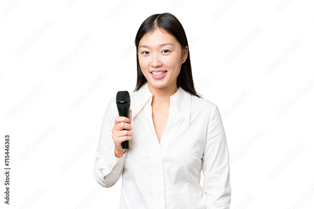 Singer picking up a microphone over isolated chroma key background smiling a lot Singer picking up a microphone over isolated chroma key background smiling a lot