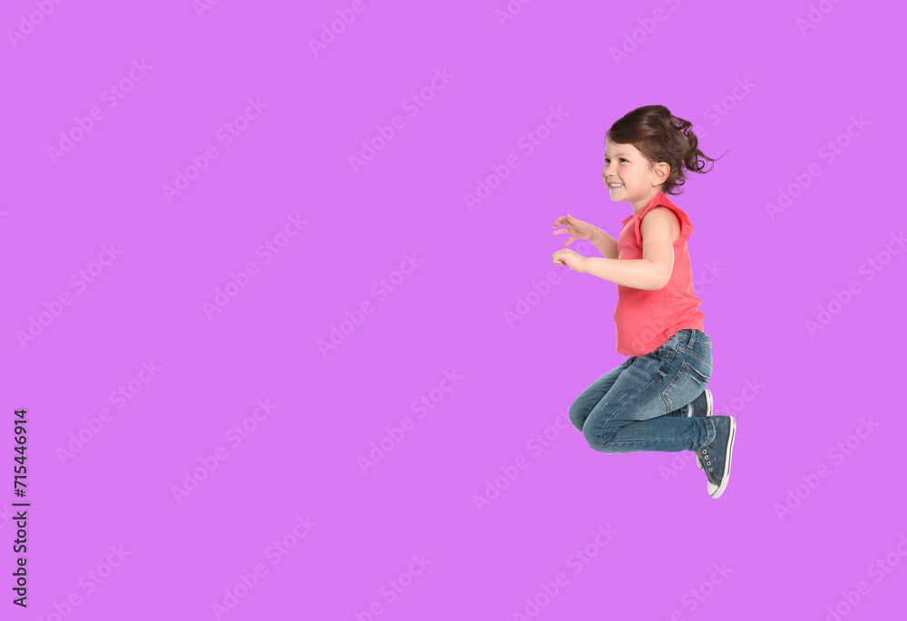 Cute girl jumping on violet background, space for text Cute girl jumping on violet background, space for text