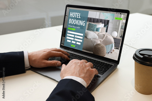 Wallpaper Mural Man using laptop to book hotel at white table, closeup Torontodigital.ca