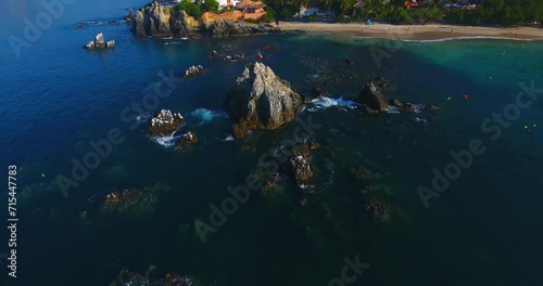 Pushing out and tilting up to reveal a gorgeous development on the peninsula of a beautiful city on the Pacific Ocean in Mexico photo