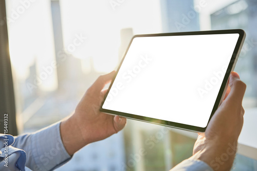 Hands of businessman holding tablet PC with blank screen photo