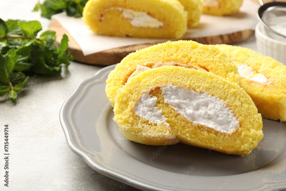 Delicious cake roll with cream filling on grey table, closeup Delicious cake roll with cream filling on grey table, closeup