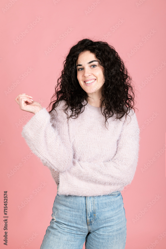 Happy young woman standing against pink background Happy young woman standing against pink background
