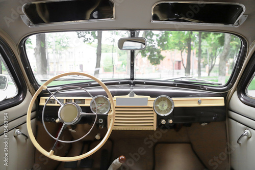 retro car interior. Vintage dashboards. Luxury leather steering wheel. Auto controls.
White interior. Car chairs and seats. Car sofa. Back and front row. Interior and door trim. Classic look