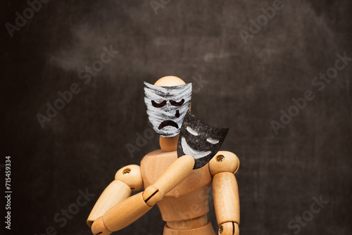 Canvas Print A wooden mannequin changes a mask of sadness to a cheerful mask.