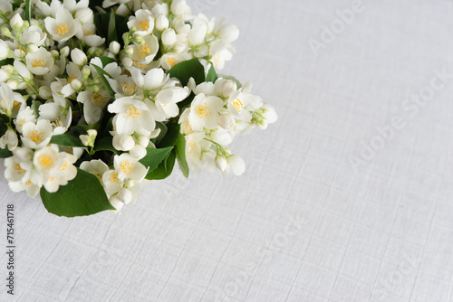 Bouquet of fresh delicate spring jasmine flowers on a linen tablecloth on the table. Top view  empty space.