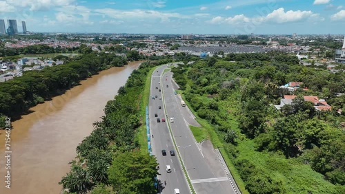 Aerial View of road with big brown river and blue sky. photo