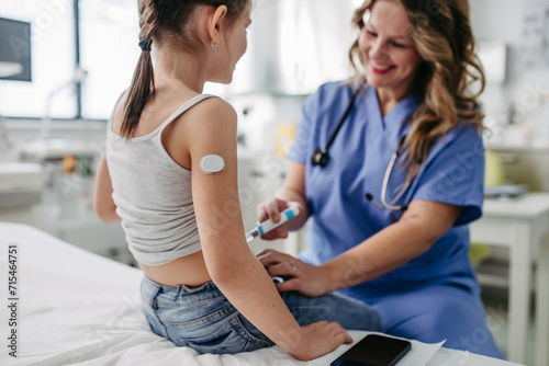 Nurse injecting insulin in diabetic girl belly. Close up of young girl with type 1 diabetes taking insuling with syringe needle.