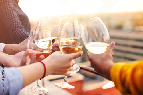 Crop friends clinking glasses of wine photo