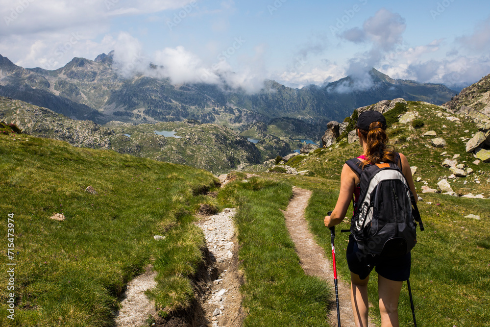 Obraz premium Young hiker girl summit to Ratera Peak in Aiguestortes and Sant Maurici National Park, Spain