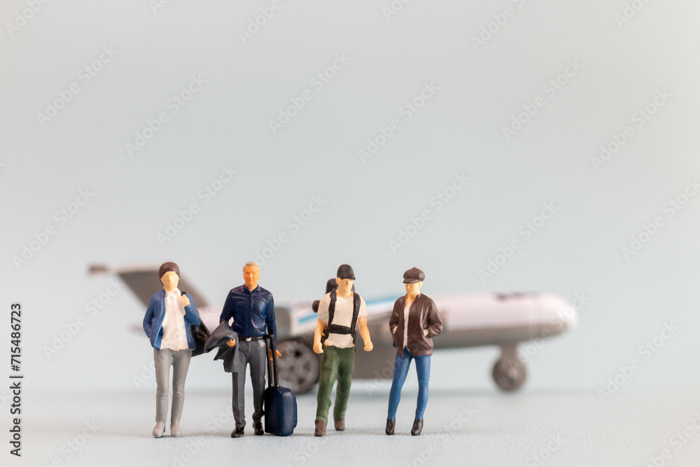 Fototapeta premium Miniature people, travelers embarks on a delightful vacation, gleefully boarding a tiny airplane
