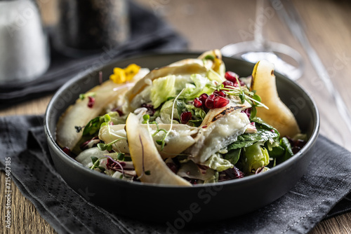 Healthy salad with goat cheese, lettuce, pears and pomegranate