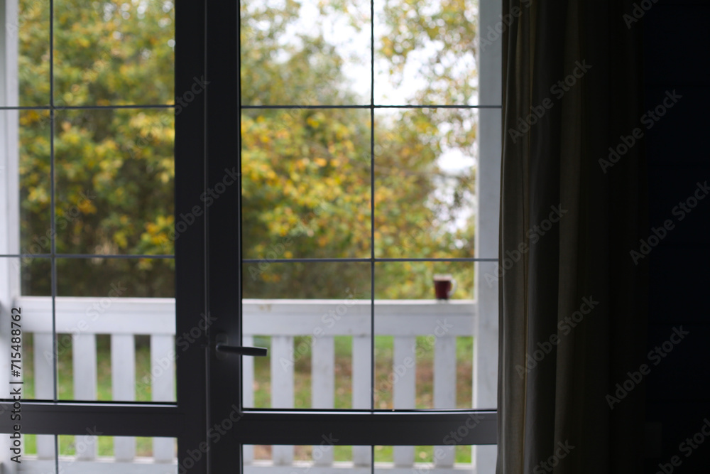 Grey cup with tea or coffee, morning terrace, look through the window Grey cup with tea or coffee, morning terrace, look through the window