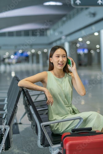 Asian woman chatting with friends while waiting at the transportation departure hall