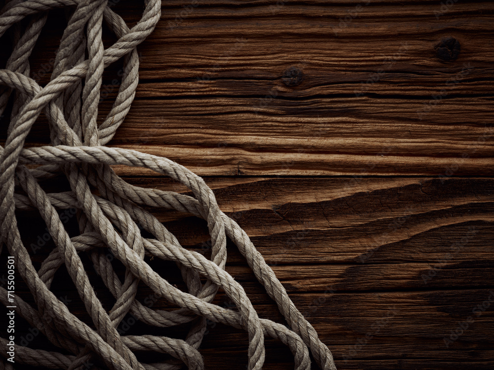 Dark vintage marine background with old hemp rope over wooden planks