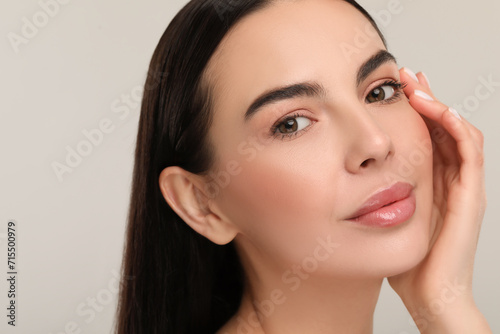 Beautiful woman with healthy skin on gray background, closeup