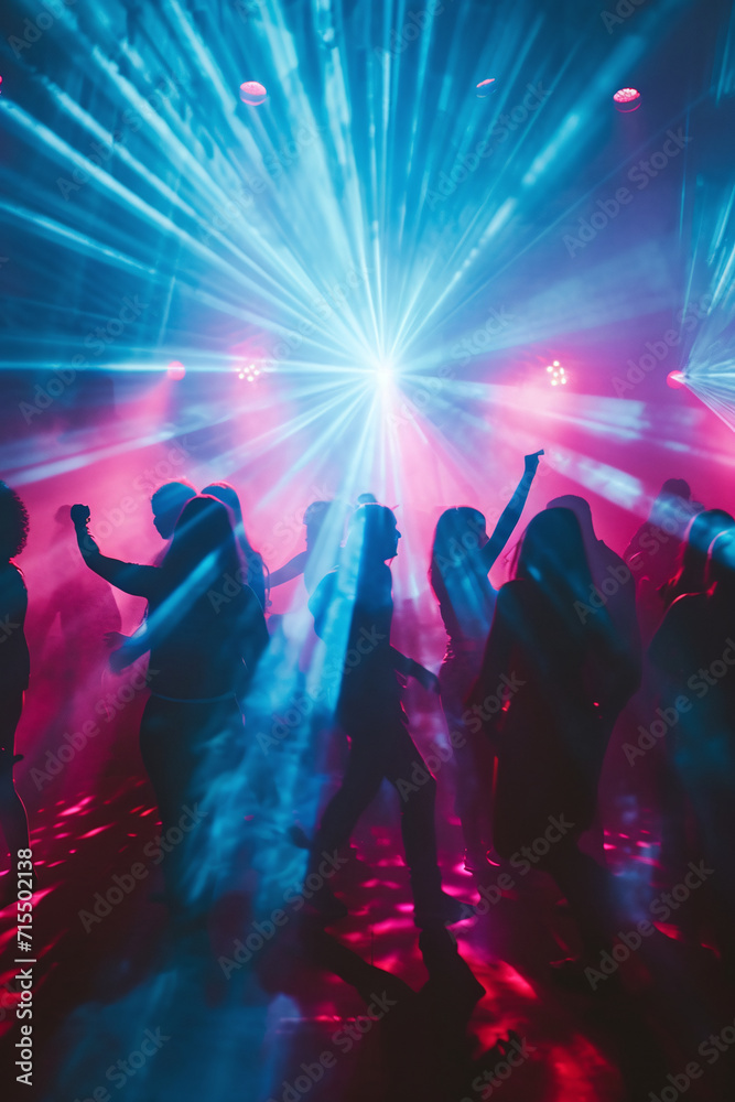 Silhouettes of people dancing at a club with vibrant blue and pink lights
