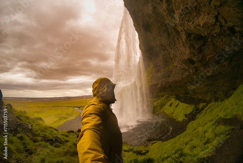 man observing the Seljalandsfoss waterfall