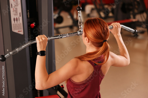 Young woman training in modern gym, back view