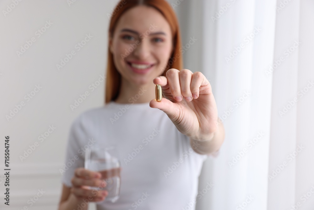 Beautiful young woman with vitamin pill and glass of water, selective focus Beautiful young woman with vitamin pill and glass of water, selective focus