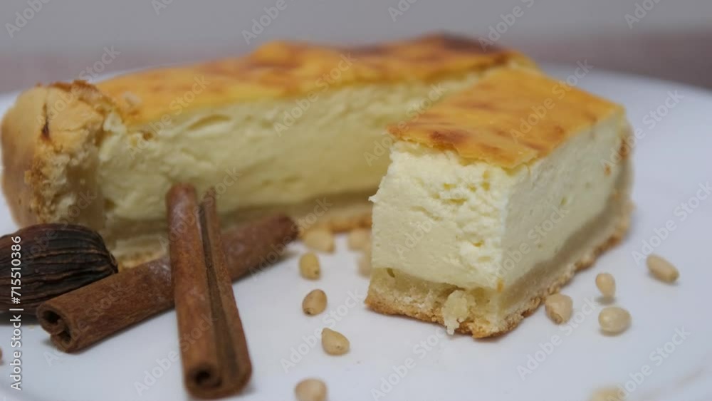 burnt cheesecake on white plate. cinnamon sticks sprinkled with pine nuts burnt cheesecake on white plate. cinnamon sticks sprinkled with pine nuts