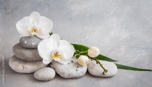 white orchid and spa stones on the grey background
