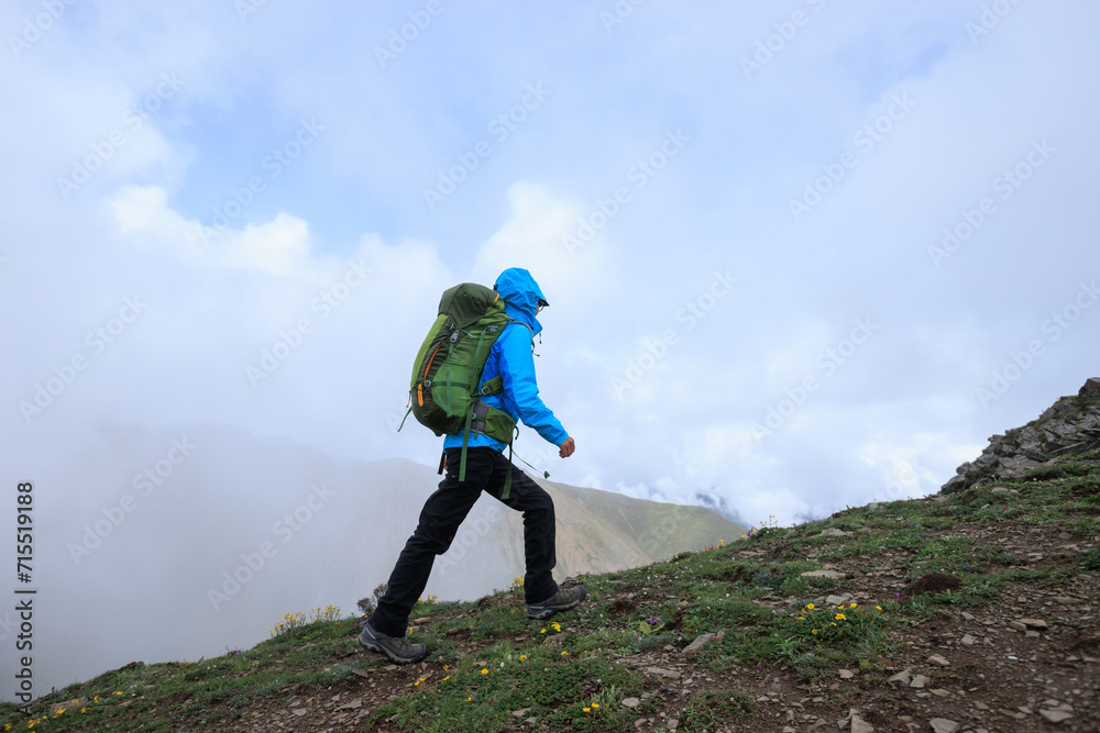 Woman hiker climbing to mountain top in tibet