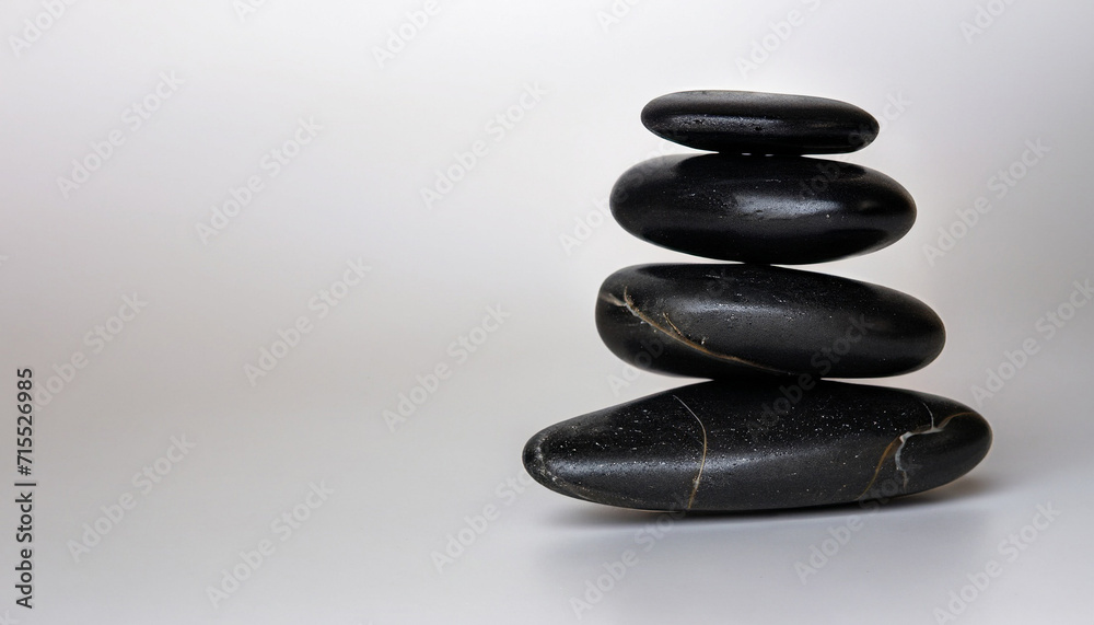 Black zen stones stacked on white background in wellness concept with free copyspace for text Black zen stones stacked on white background in wellness concept with free copyspace for text